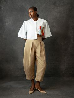 Babayo’s Balloon Pants are named after their exaggerated barrel legs that curve at the sides. They’re cut from hand-woven Aso Oke cotton and tailored to a relaxed, high-waisted profile that hits just right above the ankle. The fitted waistband and pleated detailing enhance the dramatic shape, while the versatile sand shade means they’re incredibly versatile when it comes to styling. Style yours with the label's matching Embroidered Crop Top. - Fitted waist, pleated detailing, side zip fastening, Barrel Pants Outfit, Tailored Pants Outfit, Barrel Pants, African Luxury, Dress Stole, Corporate Attire, Embroidered Crop Tops, Balloon Pants, Aso Oke