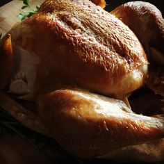 a whole turkey sitting on top of a wooden cutting board