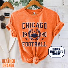 Please Note: This listing contains multiple shirt types. To insure you are getting the item you expect, please review all options and photos carefully before ordering. Our Chicago Football Apparel is the perfect way to cheer on your team this season. Choose from short sleeve tees, sweatshirts or hoodies. Makes a great gift for any fan. Perfect for game day, tailgates or everyday wear.  SHIRT DETAILS Bella Canvas Unisex - Solid colors: 100% Cotton. - Heather colors: 52% Cotton + 48% Polyester - Runs true to size. (For looser or oversized fit consider going up a size or 2. See photos for size chart.) SWEATSHIRT & HOODIE DETAILS Gildan Heavy Blend Unisex - 50% Cotton + 50 Polyester - Runs true to size. (For looser or oversized fit consider going up a size or 2. See photos for size chart.) CAR Fall Team Spirit T-shirt For Streetwear, Team Spirit T-shirt For Streetwear In Fall, Fall Streetwear T-shirt With Team Spirit, Winter College T-shirt With Screen Print, Varsity Style Sports T-shirt For Fall, Orange Crew Neck Top For Sports Season, Orange Crew Neck Top For Sports Events, Sporty Winter T-shirt For Fans, Sporty Winter T-shirt For Sports Events