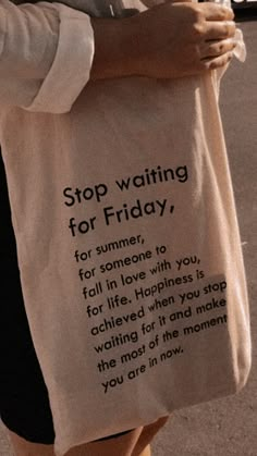 a woman carrying a shopping bag that reads stop waiting for friday, for someone to fall in love with you