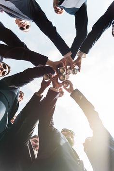 a group of people standing in a circle with their hands on top of each other