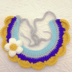 a crocheted bib with a flower on it