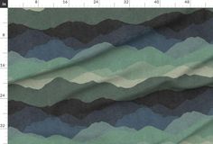 an image of a green and blue fabric with mountains in the background on a ruler