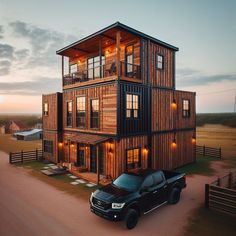 a black truck parked in front of a tall wooden building with lights on it's windows