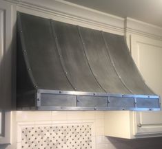 a stainless steel range hood mounted on the side of a kitchen wall above a stove