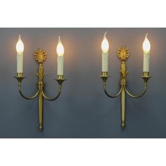 three light wall sconces with white candles on them