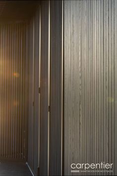 an open door leading to another room with wooden slats on the walls and floor