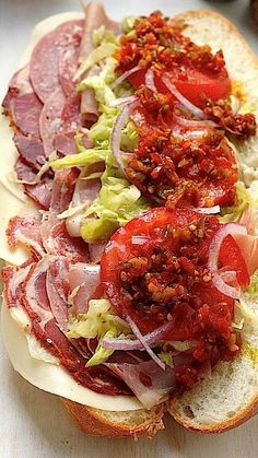 a close up of a sandwich on a plate with meat and veggie toppings