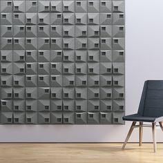 a chair sitting in front of a wall made out of cubes on it's side