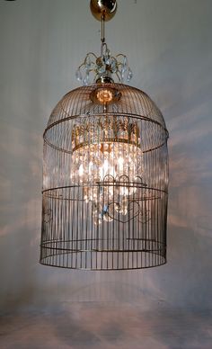 a birdcage with chandelier hanging from the ceiling