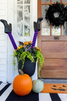 halloween decorations on the front porch with pumpkins and witch's legs sticking out