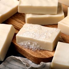 several pieces of soap sitting on top of a wooden cutting board