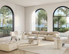 a living room filled with white furniture and large windows overlooking the water in front of them