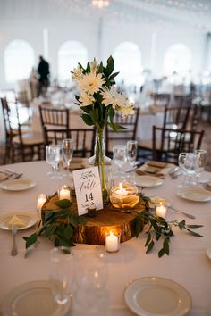 a centerpiece with flowers and candles is displayed on a table at a wedding reception