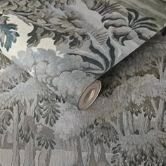 a close up view of a wallpaper with trees and flowers on the fabric,