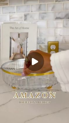 a person is placing an item in a bowl on the counter top, with text overlay that reads amazon house and budget