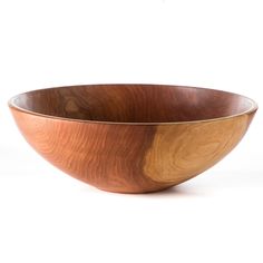 a wooden bowl sitting on top of a white table