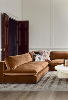 a living room filled with furniture on top of a hard wood floor covered in white walls