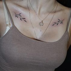 a woman's chest with three small tattoos on it