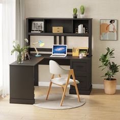 a desk with a laptop computer on top of it next to a potted plant