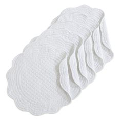 six pieces of white quilted placemats stacked on top of eachother