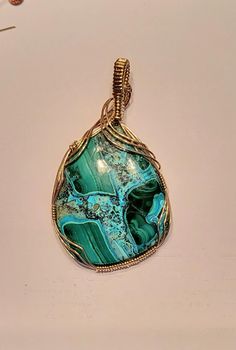 Bold Slide pendant featuring a beautiful 40x50mm gemstones with vibrant green Malachite and Caribbean blue Chrysocolla. It is hand crafted in 14K Yellow gold filled wire.  It has a 9x10mm bail opening to fit nearly any thickness of chain or up to a 10mm omega.  It measures approximately 2 3/4 inches long.  Looking for a certain color? Just ask!!  Matching earring charms are sold separately in my store.  All measurements are as close as possible within the limitations and restrictions imposed by Green Freeform Jewelry For Gifts, Hand Wrapped Green Pendant Jewelry, Handmade Freeform Green Jewelry, Green Agate Teardrop Jewelry, Turquoise Malachite Jewelry Gift, Handmade Green Freeform Jewelry, Gold Bohemian Jewelry With Malachite, Handmade Gold Malachite Jewelry, Green Wire Wrapped Agate Jewelry