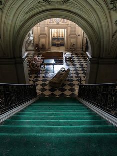 the stairs are green and black with checkerboard flooring in an old building