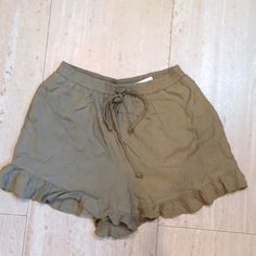 Army Green Color. Stretch Waist With Drawstring. Side Pockets. Ruffled Bottoms. Casual Cotton Ruffle Shorts, Summer Ruffle Shorts For Beach Season, Summer Ruffled Shorts For Beach Season, Casual Green Shorts With Ruffles, Casual Green Ruffled Shorts, Green Ruffled Shorts For Summer, Casual Ruffled Bottoms For Beach Season, Ruffled Shorts For Beach Season, Ruffled Beach Season Shorts