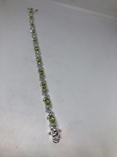 This Peridot bracelet is very lively and bright. The stones are deep colors and well matched. The sterling silver is plated with rhodium to protect the bracelet from tarnish and give the appearance of white gold. 7.5 inches My jeweler can shorten it for a $20 fee All jewelry is shipped in a nice gift box. Check out our over a THOUSAND great reviews Engraving is $4 per letter and is not always perfect depending on the piece. It can take a few days if the jeweler is busy. This is payable to Paypal Green Multi-stone Round Bracelets, Elegant Green Bracelets With Sterling Silver Clasp, Green Round Sterling Silver Bracelet, Green Multi-stone Bracelets For Gifts, Green Sterling Silver Round Bracelet, Green Sterling Silver Bracelets With Silver Clasp, Green Sterling Silver Bracelets Fine Jewelry, Green Gemstone Sterling Silver Round Bracelet, Green Sterling Silver Bracelets, Fine Jewelry