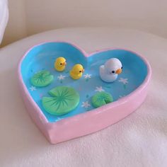 a heart shaped bathtub with rubber ducks in it