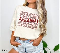 This Arkansas shirt is perfect for gameday, tailgating, or for any Arkansas fan or football mom! *:･ﾟ･ﾟ DETAILS *:･ﾟ･ﾟ This is a direct to garment print, no vinyl or stencils. Which means it will last a lot longer!  Comfort Colors tees are UNISEX SIZES. The soft-washed, garment-dyed fabric brings extra coziness to your wardrobe while the relaxed fit makes it an excellent daily choice. Size up at least 2 sizes for the oversized/tshirt dress look. We recommend laying a favorite tee flat and measuring it before ordering to get the perfect fit. *:･ﾟ･ﾟ WASHING *:･ﾟ･ﾟ PLEASE WASH BEFORE WEARING - some items may feel slightly stiff when you receive them. This happens occasionally and is normal due to the direct to garment printing process. Please wash to reveal the true softness of your new favor White Casual Top For Tailgating, Casual White Top For Tailgating, Arkansas Shirts, Gameday Tshirts, Arkansas Shirt, Tailgate Shirt, Football Tailgate, College Tees, Preppy Clothes