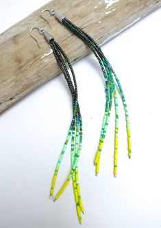 "Spring Chain" A playful harmony of cool dark green seed beads rest against threads of soft grass green and a pop of yellow. These long earrings feature a splash of mint and creamy blue accents. A pop of subtle spring colors make these earrings easy to wear as a daily favorite. 925 silver earwires finish the look.Please choose your length at check out:4 inches6 inches9 inchesPhotos show our extra long pair of earrings measuring 9 inches from top of earwire to bottom.Your jewelry will come beauti Cheap Green Beaded Earrings For Summer, Mirror Earrings, Homemade Earrings, Beaded Chandelier Earrings, Beaded Earrings Tutorials, Beaded Earrings Diy, Beaded Jewlery, Green And Silver, Seed Bead Tutorial