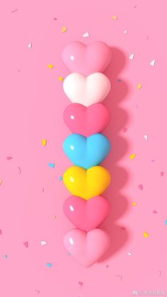 three heart shaped balloons on a pink background