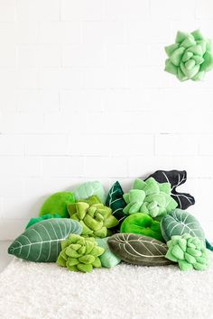 green flowers and leaves on white carpet in front of brick wall