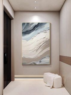 an abstract painting hangs on the wall in this modern hallway with white and beige decor