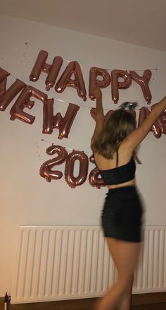 a woman standing in front of a happy new year sign