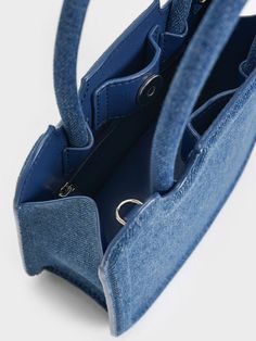 For a fresh and modern take on the everyday bag, look no further than this Perline sculptural top handle bag in full denim. It features a boxy and structured silhouette, marked by clean lines and a minimal design, that will effortlessly complement casual and dressy outfits alike. The magnetic closure offers easy access to your belongings while the bag can be carried in multiple ways - hold it by the top handles, hang it on the crook of your arm, or sling it on your shoulders. Brand Collaboration, Size Chart For Kids, Charles Keith, Kids Sale, Dressy Outfits, Printables Kids, Everyday Bag, Handle Bag, Minimal Design