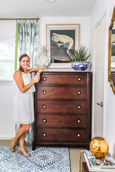 a woman standing in front of a dresser