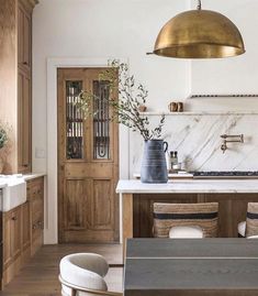 a kitchen with marble counter tops and wooden cabinets, along with an island in the middle