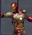 an iron man statue is posed in front of a building with his arms outstretched and hands out