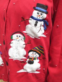 the snowmen are wearing hats and scarves on their sweaters as they stand next to each other