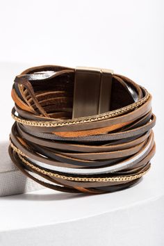 Our On the Line Bracelets are marvelously stackable! This piece features soft flexible leather adorned with a gorgeous sheen that makes it pop. Whether your style is chic, rustic, or in-between, we have a color combination for you. Materials: Leather, Zinc, Alloy Size: 8” x 1.5” Magnetic Clasp Imported Trendy Brown Bracelet As Fashion Accessory, Trendy Brown Bracelets As Fashion Accessory, Chic Adjustable Double Band Bracelet, Trendy Brown Wrap Bracelet Gift, Trendy Gold Leather Bracelet, Trendy Brown Leather Bracelet, Trendy Adjustable Brown Leather Bracelet, Trendy Brown Bangle Jewelry, Chic Adjustable Leather Bracelet