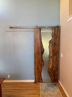 a room with a door that is made out of wood and has a mirror on the wall