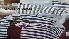 a bed covered in blue and white striped sheets next to a night stand with an alarm clock on it