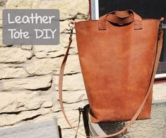 a brown leather tote bag sitting on top of a table next to a window