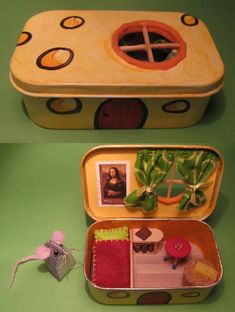 two tins with pictures in them on a green surface and one has a mouse