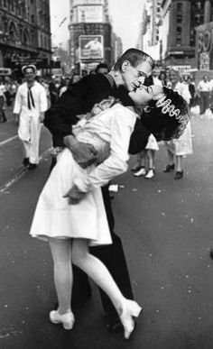 a man and woman kissing on the street