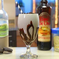 an ice cream sundae in a glass with chocolate and oreo cookies on the side