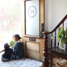 two children sitting on the floor in front of a window