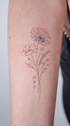 a woman's arm with a flower tattoo on the back of her left arm